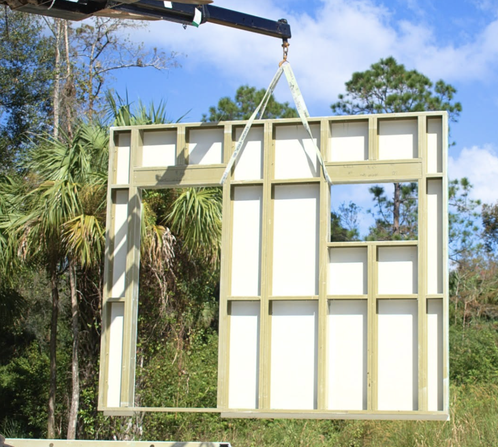 Construction photograph · a composite wall panel being lifted